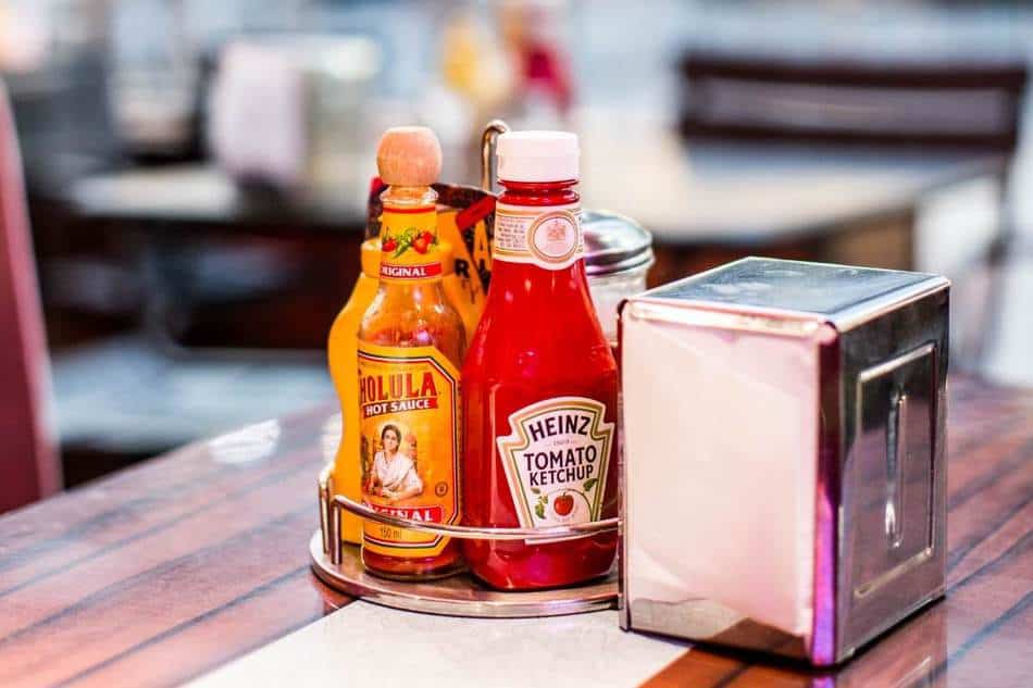 ketchup, mustard, and paper on a restaurant table.